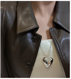 Detail eines polierten S925 Silber Hohlherz-Anhängers an einer Perlenkette für Damen