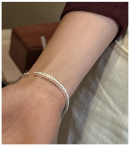 Close-up of S925 sterling silver cuff bracelet with engraved vintage patterns on wrist
