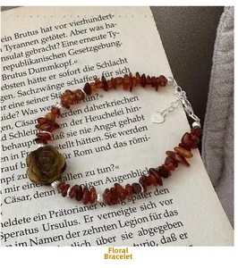Macro detail of S925 silver rose bracelet with amber stones and heart tag on vintage book