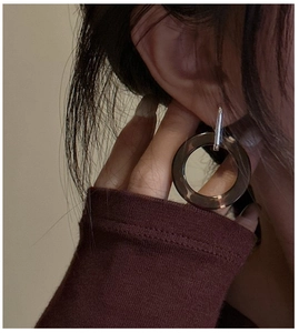 Close-up of geometric amber resin hoop earrings with S925 silver metal stud on model