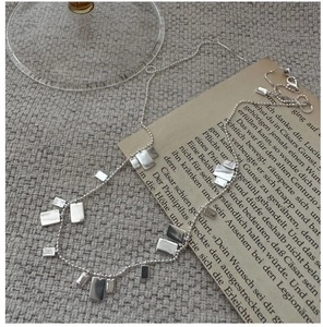Dettaglio del ciondolo quadrato in argento sterling S925 con texture spazzolata