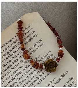 Close-up of retro silver bracelet with red amber beads and tiger eye rose charm