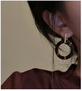 Close-up of S925 silver stud earring with vintage amber resin ring on model ear