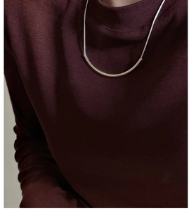 Détail du collier sourire en argent S925 sur maille bordeaux montrant le pendentif minimaliste