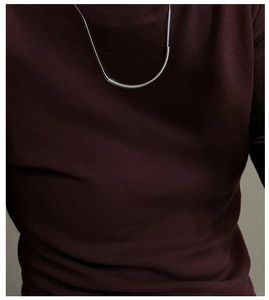 Gros plan d'un collier en argent S925 avec pendentif barre courbe minimaliste