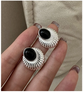 Détail de boucle d'oreille en argent S925 avec texture coquillage et onyx noir serti