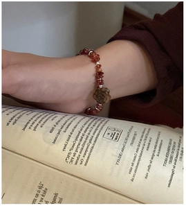 Close-up of S925 silver beaded bracelet with reddish stones and a brown rose flower charm