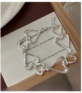 Détail macro du bracelet cœur en argent texturé avec finition en métal martelé rustique