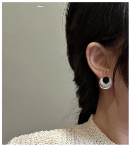 Gros plan d'une boucle d'oreille rétro en argent S925 avec onyx noir et texture
