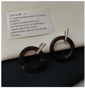 Detail of tortoise shell resin hoop earrings with minimalist silver metal clasp