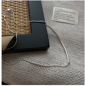Vue détaillée du collier sourire en argent sterling S925 sur un tissu texturé élégant