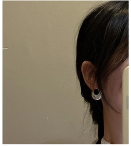 Détail macro de boucles d'oreilles vintage en argent S925 avec onyx noir et motif radial