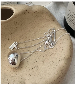 Macro detail of S925 silver necklace with irregular lava pendant and OT buckle on tray