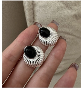 Gros plan de boucles d'oreilles en argent S925 avec onyx noir et texture rayon de soleil