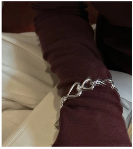 Gros plan d'un bracelet à maillons en forme de cœur en argent S925 sur une manche