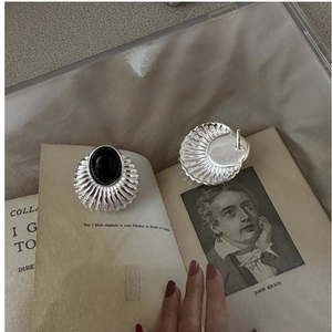 Détail de boucles d'oreilles coquillage en argent S925 avec onyx noir sur livre