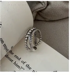 Détail macro de la bague croisée vintage en argent S925 sur un livre ouvert