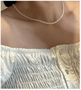 Detail of S925 sterling silver woven lace chain necklace on model neck and collarbone