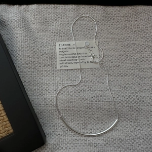 Collier minimaliste en argent sterling S925 avec barre incurvée sur tissu neutre