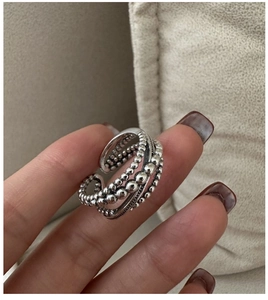 Gros plan d'une bague multicouche perlée en argent S925 avec texture vintage
