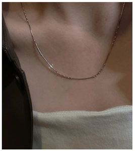 Close-up of minimalist rose gold snake chain necklace on model neck showing fine bead details