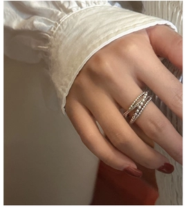 Vue macro détaillée de bagues multicouches en argent S925 avec texture tissée sur le doigt