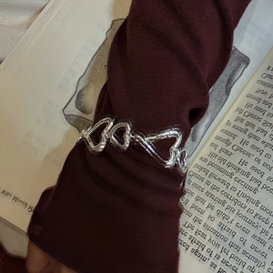 Bracelet S925 en argent avec cœurs texturés porté sur le poignet pour un look rétro