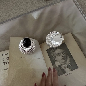 Boucles d'oreilles vintage en argent S925 et onyx noir sur un livre ancien
