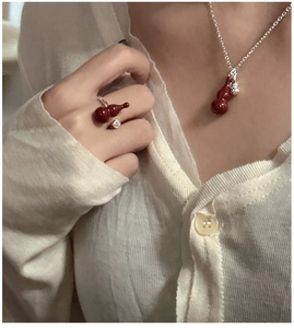 Close-up of S925 silver necklace and ring set with Angola red gourd pendants on a model