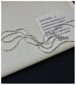 Close-up of S925 sterling silver snake chain with polished beads and lobster clasp detail