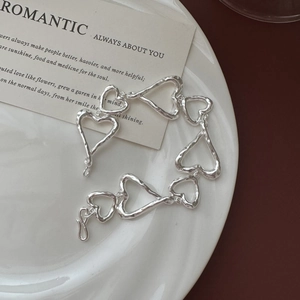 Bracelet à maillons cœur en argent S925 avec texture martelée sur une assiette blanche