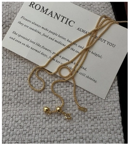 Close-up of S925 sterling silver woven chain with heart slider and gold finish