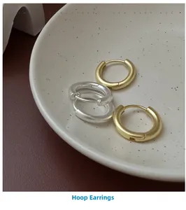 Detail of matte finish minimalist S925 silver hoop earrings in gold and silver