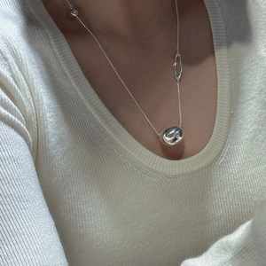 S925 sterling silver bean pendant necklace on a cream knit sweater for a minimalist look