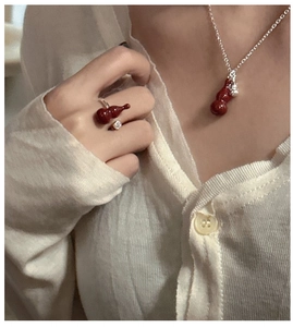 Detail showing an S925 silver necklace and open ring set with red gourd pendants