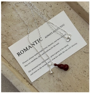 Close-up of S925 silver necklace with red gourd pendant and small silver charm