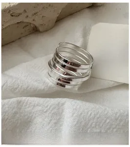 Detailed view of multilayer S925 sterling silver ring on a textured stone surface