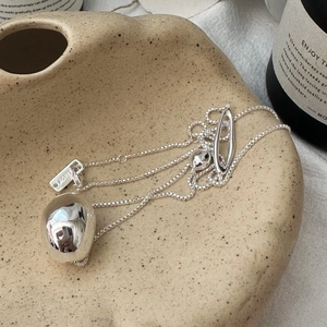 Minimalist S925 sterling silver liquid lava pendant necklace on a ceramic plate