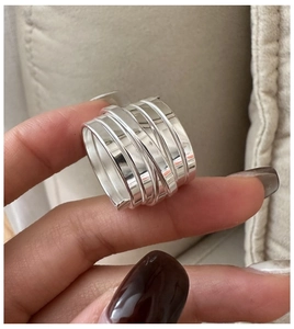 Detailed view of polished S925 sterling silver multilayer spiral wrap ring held in hand