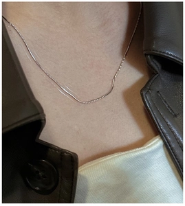 Dettaglio di una collana a catena a serpente in argento 925 indossata con giacca in pelle