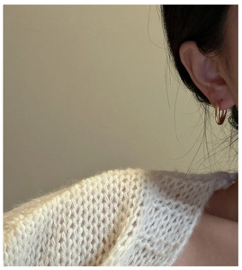 Detailed view of elegant gold hoop earring on model with matte finish texture