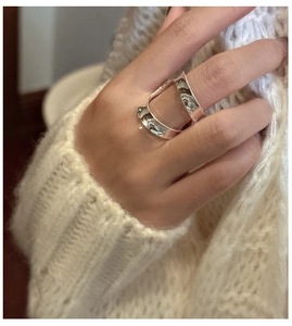 Close-up of minimalist S925 sterling silver wide curved double layer ring on female hand