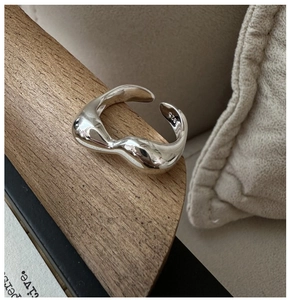 Makroaufnahme des S925 Sterling Silber Wellenrings mit polierter Oberfläche auf Holz