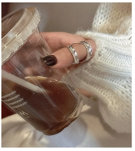 Detail of S925 sterling silver double-layered wavy ring worn on thumb with knit texture
