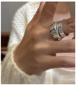 Detail of S925 sterling silver multilayer winding ring shown on finger for a modern style