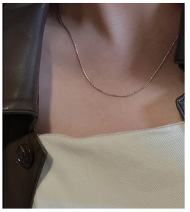 Dettaglio della collana minimalista in argento sterling 925 con catena a spina di pesce su modella