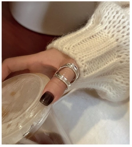 Minimalist S925 sterling silver wide curved ring styled on finger in a cafe setting