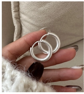 Macro shot of silver matte finish hoop earrings with thick minimalist brushed metal texture
