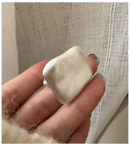 Close-up of a large minimalist square silver ring with a matte brushed metal finish
