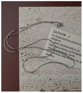 Dettaglio catena snake in argento sterling 925 su pietra beige con finitura lucida